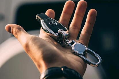 Man holding Mercedes car key in hand