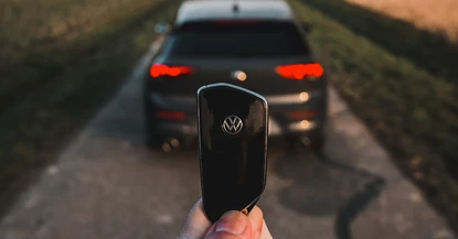 An image of a Volkswagen Golf and a person holding the car key up