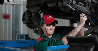 An image showing a woman working on a car
